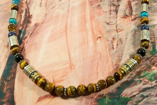 Stunning Necklace featuring Genuine Tiger's eye with Genuine Turquoise Coral, Blue Lapis and Black Onyx Accents. Beautiful Gold fill and Sterling Silver Barrels, Beads and Clasp.  Created by Navajo Artist Tommy Singer. Signed by the artist.